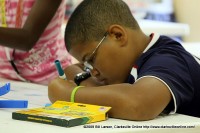 A young man colors while participating in the City of Clarksville's Summer youth program