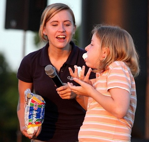 A marshmellow drops out of a young girls mouth knocking her out of the chubby bunny contest.