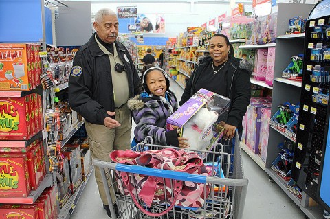 Officer Booker Dailey helping a young shopper. (Photo by CPD-Jim Knoll) Officer Booker Dailey helping a young shopper. (Photo by CPD-Jim Knoll)