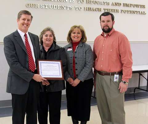 School Board member Josh Baggett presents the School Board Point of Pride award to FCFCU president and CEO Stewart Ramsey, vice president of retail operations Melody Swindall and executive vice president Maria McKee.