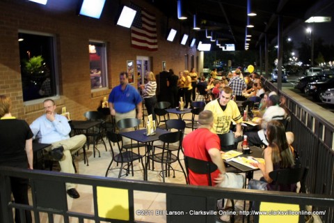 A friendly Buffalo Wild Wings waiter talks with his customers on the patio