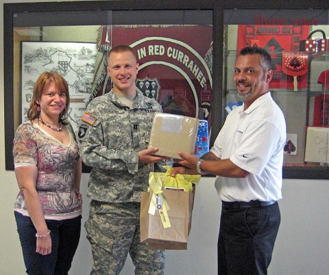 Wyatt-Johnson auto rep Willie Rosario presents sheets and a gift bag to FRG leader Tammy Phillips and Cpt. Smith, rear detachment commander for 4th Brigade Combat Team 506th Infantry Regiment.