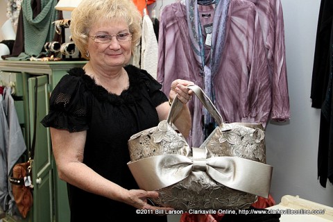 Author Sue Culverhouse holding up one of the fine handbags offered at Rogate's Boutique