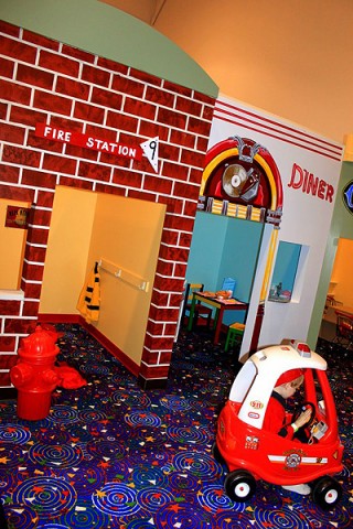 A child dresses up as a firefighter in Tot-ville.