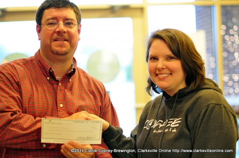 Sango Lasaters manager Megan Ryle presents Lasaters Christmas Giveaway winner Michael Clark with the prize of $1000 in the form of a check Friday, December 23rd.