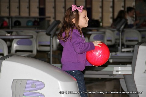 A little girl bowling at the fundraising event at the Pinnacle.