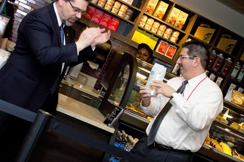 Dr. Tristan Denley, provost and vice president of academic affairs, and Joe Lachina, senior dining services director, cut open a bag of coffee instead of a ribbon at the Starbucks grand opening. (Photo by Amber Fair/APSU)