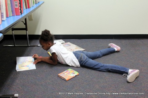 This young lady is enjoying one of her new books in the children's section.