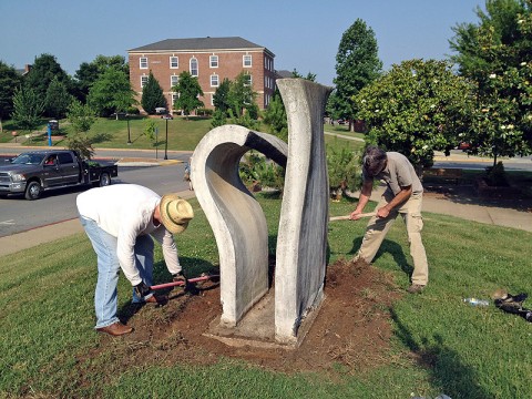 Christopher Burawa, left, works with artist Mike Andrews to restore Andrew’s sculpture, “Light Modulator.”