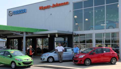 Wyatt Johnson is offering the winning student his or her choice of three different cars. Katherine Johnson Cannata, Syd Johnson and Bill Powers stand next to the three options a Toyota Yaris, a Mazda 2 or a Hyundai Accent.