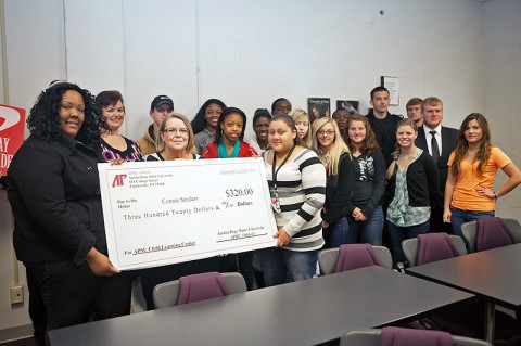 Students in the APSU 1000 class taught by Lynette Taylor present a ceremonial check November 14th to Connie Sanders (standing behind check in the middle), director of the APSU Child Learning Center, to help with playground improvements. (Photo by Jennifer Oliphant, APSU Public Relations and Marketing)