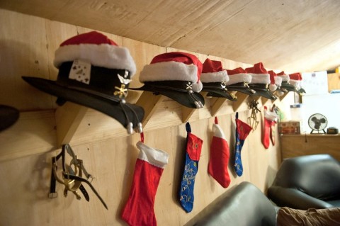 Stetsons adorned with Christmas hats and unit badges hang neatly in a row alongside spurs and stockings as the Yuletide season approaches at Forward Operating Base Fenty, Afghanistan. (U.S. Army photo by Sgt. Duncan Brennan, 101st CAB Public Affairs) Stetsons adorned with Christmas hats and unit badges hang neatly in a row alongside spurs and stockings as the Yuletide season approaches at Forward Operating Base Fenty, Afghanistan. (U.S. Army photo by Sgt. Duncan Brennan, 101st CAB Public Affairs)
