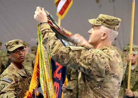 U.S. Army Command Sgt. Maj. Tonika Scott-Morris (left), and Lt. Col. Scott Noon, Division Headquarters and Headquarters Battalion, 101st Airborne Division (Air Assault) command team, uncase the unit flag during the casing ceremony for the division headquarters battalion for the outgoing 1st Infantry Division and the uncasing ceremony for the division headquarters battalion for the incoming 101st Airborne Division (Air Assault), Feb. 28, 2013, at Bagram Airfield. (U.S. Army photo by Sgt. 1st Class Kevin Hartman, 115th Mobile Public Affairs Detachment)