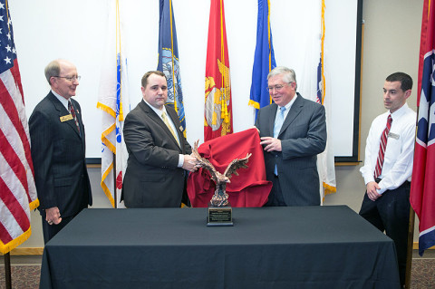 Dr. Lowell Roddy (from left), APSU Student Veterans Organization adviser, SVA President Michael Cleveland, APSU President Hall and Military Student Center Coordinator Justin Machain unveil the national award from the Student Veterans of America during a ceremony held Monday, March 18th. (Photo by Beth Liggett, APSU photographer)