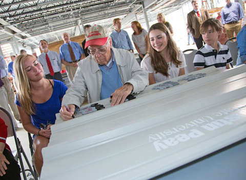 James Maynard — the first to sign during Tuesday's topping-off ceremony at the Maynard Mathematics and Computer Science Building at APSU — is surrounded by some of his grandchildren. (Photo by Beth Liggett, APSU photographer)