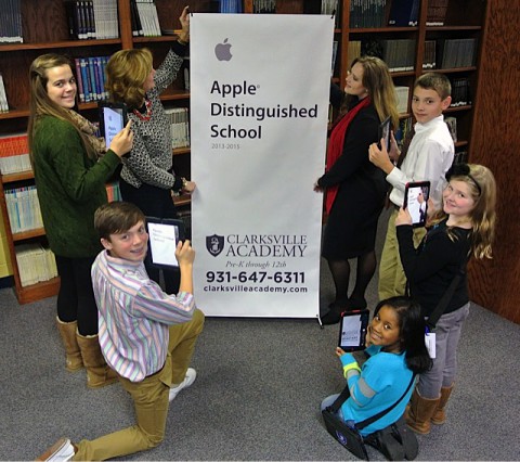 Head of School Kay Drew & Technology Director Cara Miller unveil the Apple Distinguished School banner while current students capture the moment on their school issued iPads. 