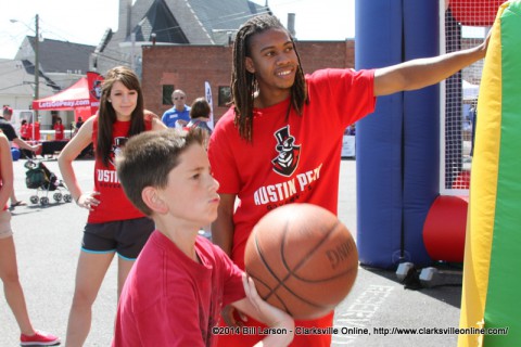 APSU students watch as a young boy demonstrates his basketball skills at the Rivers and Spires Festival Sports Zone