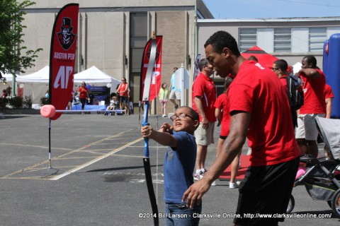 APSU students help a young boy with his archery skills at the 2014 Rivers and Spires Festival Sports Zone