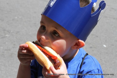 A young boy takes his first taste of a Johnsonville Brat