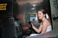 A young girl takes her hand at one of the Apache helicopter simulators in the Total Army Experience at the 2014 Rivers and Spires Festival