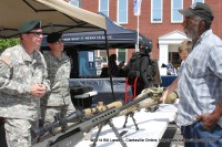 5th Special Forces Group Soldiers talk with a military veteran about the weapons they use on the modern battlefield