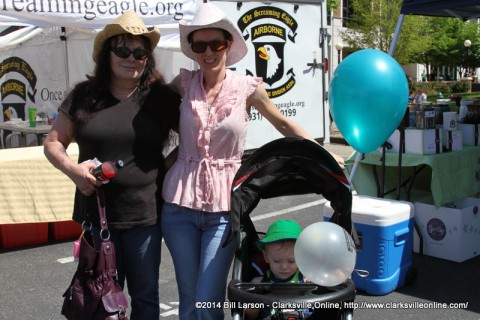 A family poses for a photograph in front of the 101st Airborne Association booth at the 2014 Rivers and Spires Festival 
