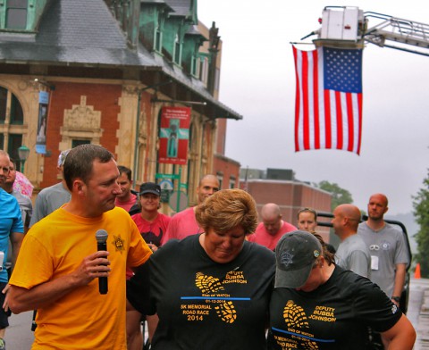 Montgomery County Sheriff John Fuson speaks to the crowd while embracing Jennifer and Shelby Johnson, the family of fallen Deputy David “Bubba” Johnson.