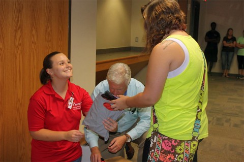 APSU residence hall director for Castle Heights and nursing major, Ashlee Dover and Darrel Smith, representative from Geiger present a packet with the Liv kit to a freshman student.