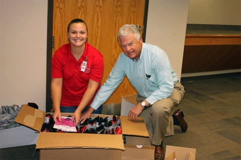 APSU residence hall director for Castle Heights and nursing major, Ashlee Dover and Darrel Smith, representative from Geiger stuff new student packets with the Liv kit.