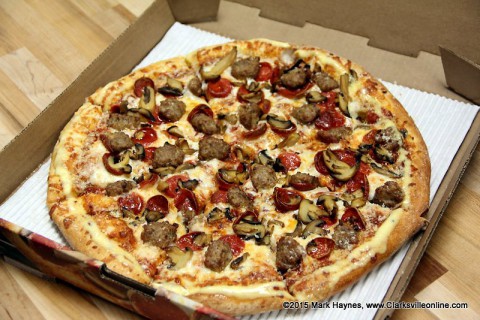 A pepperoni, italian sausage and mushroom pizza.