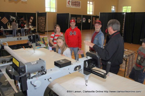 A young lady looks at a quilting machine at Quilts of the Cumberland.