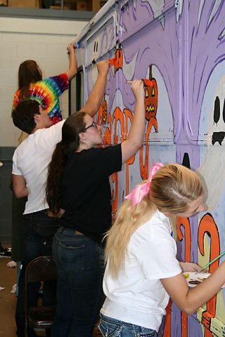 Clarksville Academy art students put the finishing touches on their Spooky Special paint job at the CTS maintenance garage on Friday.