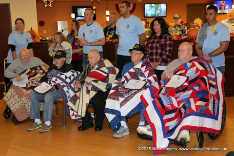 Veterans at Clarksville's Tennessee State Veteran's Home receive Quilts of Valor with members of the Sergeant Audie Murphy Association standing behind them.