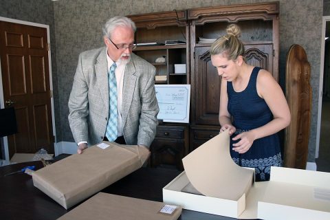 Customs House Museum Director Jim Zimmer and Curator of Collections Kali Mason examine the newly restored Civil War diary of Serepta Jordan. The diary was found in a smoke house near Clarksville and given to the Museum in 1984.