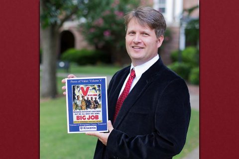 Austin Peay State University Associate Professor Kevin Tanner holds up a copy of his latest volume release of the book "Faces of Valor."