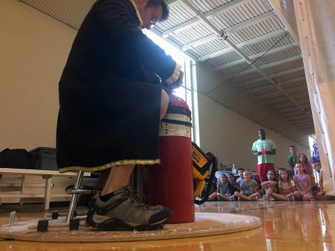 Austin Peay State University’s Bryan Gaither prepares to don an Iron Man mask and his across the gym floor on his homemade hovercraft. Attendees of the university’s Junior Govs Summer Camp are in the background. (APSU)