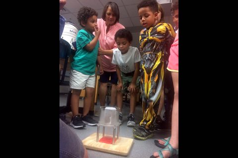 Kids watch as a metal ball moves SLOWLY through a liquid nitrogen-chilled magnet during a science demonstration at Austin Peay State University. (APSU)