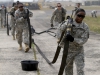 Spc. Raven Attaway, a fuel handler with the 101st Sustainment Brigade, Task Force Lifeliners, Joint Forces Command - United Assistance, deployed in support of Operation United Assistance, leads the way with fuel hoses onto the tailgate of a Cargo Helicopter 47 (CH-47) Chinook during a fuel handlerâ??s class at Roberts International Airport outside of Monrovia, Liberia, Jan. 15, 2014. The training teaches Soldier how to implement the versatile Cargo Helicopter 47 (CH-47) Chinook extended range fuel system, known as the â??Fat Cow,â? which is used in environments where there is an urgent need for fuel distribution. Operation United Assistance is a Department of Defense operation in Liberia to provide logistics, training and engineering support to U.S. Agency for International Development-led efforts to contain the Ebola virus outbreak in western Africa. (U.S. Army photo by Sgt. 1st Class Mary Rose Mittlesteadt, 101st Sustainment Brigade Public Affairs/Released)