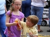 A brother and sister share a bag of chips