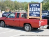 Pickup trucks carrying election signs decorate the parking lot outside the election commission.