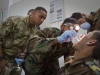 Capt. Abby Raymond, brigade dentist for the 4th Brigade Combat Team, 101st Airborne Division (Air Assault), looks over the shoulder of a medic with the ANA’s 2nd Commando Khandak, 203rd Corps, as he performs an oral exam on a fellow Commando, during a basic dental class on at forward operating base Thunder, Afghanistan, July 22. (U.S. Army photo by Sgt. Justin A. Moeller, 4th Brigade Combat Team Public Affairs)