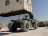 U.S. Army Spc. Casey E. Sleeman, a native of Sioux Falls, SD, and a cargo specialist, ground-guides and conducts arm and hand signals for U.S. Army Spc. Kevin E. Berry, a native of Grantsburg, WI, and a materials handler equipment operator, as Berry carries a container with a Kalmar RT-240 Rough Terrain Container Handler. (U.S. Army photo by Sgt. Sinthia Rosario, Task Force Lifeliner Public Affairs)