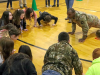 Spc. Walter Lacayo, 613th Movement Control Team, 129th Division Sustainment Support Battalion, 101st Airborne Division (Air Assault) Sustainment Brigade, leads the students of Trigg County Middle School through a warm-up exercise before their 10-meter water can challenge on Jan 28, in Cadiz, Ky. (Sgt. Aimee Nordin, 101st Airborne Division (AA) Sustainment Brigade Public Affairs)