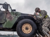 Soldiers from the 194th Military Police Company, 716th Military Police Battalion, supported on Fort Campbell by the 101st Sustainment Brigade, 101st Airborne Division, push a Humvee off of a tractor-trailer March 26 at Fort Campbell, Ky. The 194th MP was one of several units that deployed to Africa that was taking part in a mission to receive equipment returning from the deployment. (U.S. Army photo by Sgt. Leejay Lockhart, 101st Sustainment Brigade Public Affairs)