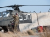 Sgt. Michael Evanson, A Company, 1st Battalion, 101st Combat Aviation Brigade, squad leader gives a salute while leaning into the wind created by the rotors of an AH-64 Apache helicopter as the Apache leaves for a mission at Forward Operating Base Salerno, Afghanistan, Jan. 16, 2013. (U.S. Army photo by Sgt. Duncan Brennan, 101st CAB public affairs)