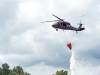 A UH-60 Black Hawk helicopter with A Company, 6th Battalion, 101st Combat Aviation Brigade, 101st Airborne Division (Air Assault)  dumps water out of a bucket slung from the helicopter during wildfire operations training at Fort Campbell, Ky., August 19, 2013. (U.S. Army photo by Sgt. Duncan Brennan, 101st CAB Public Affairs)