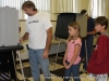 Troy Bellar votes as Zac (age 10), and Paige (age 8) look on.