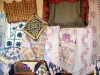 Patchwork and embroidered quilts are side by side