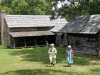 Girls dressed in period attire make their way across the grounds of Historic Collinsville.