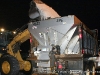 A bobcat empties a bucket of salt into the back of a salt truck